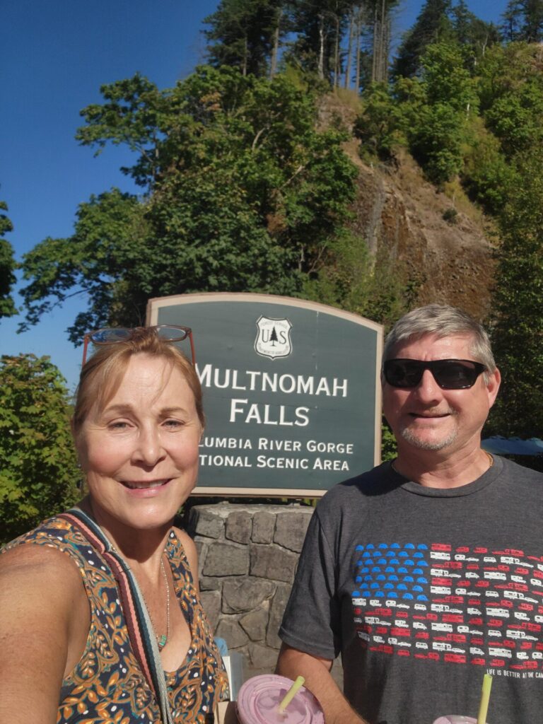 Author Larry Burklow Jr and his wife Cecilia at Multnomah Falls in Oregon during an RV trip